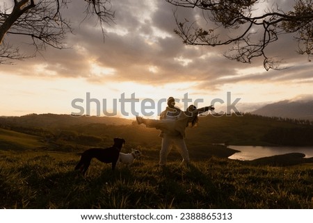 boyfriend carries girlfriend at sunset next to his pets