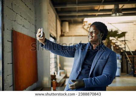 Young businessman taking selfie in office setting