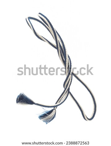 String rope obi Japanese Traditional Komono equipment fly in air with curve. String rope obi Japanese Traditional Komono fabric is beautiful clothes for ceremony event. White background isolated Royalty-Free Stock Photo #2388872563