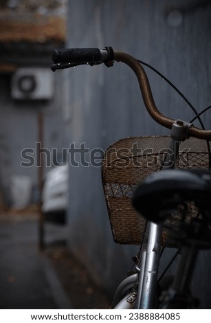 Closeup of handlebars of bike on street in a rainy day. Beijing, China
