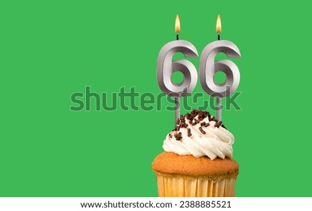 Birthday with number 66 candle and cupcake - Anniversary card on green color background Royalty-Free Stock Photo #2388885521