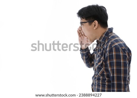 Portrait isolated cutout studio shot of Asian upset angry mad stressed male entrepreneur businessman in casual plaid shirt holding hands cover mouth shouting screaming commanding on white background.