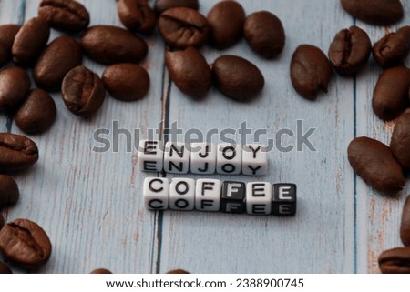 coffee beans on wooden background with word enjoy coffee