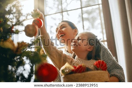 Merry Christmas, Happy Holidays. Mom and daughter near the tree indoors. The morning before Xmas. 