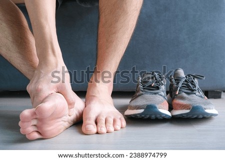 Man, foot pain and cramps in legs and ankles from Plantar Fasciitis disease Be relieved the pain with the soles of his feet.
 Royalty-Free Stock Photo #2388974799