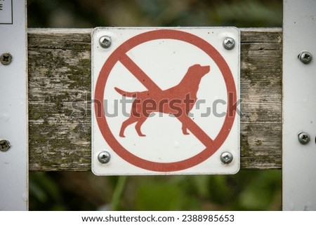 A sign attached to a gate that shows a dog crossed out - the dog is banned from the nature reserve.

Taken at Cley next the Sea in North Norfolk, England.
