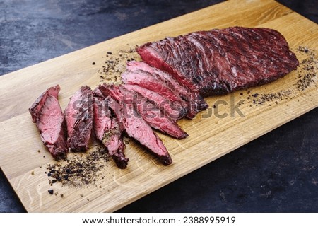 Traditional American barbecue bavette steak with salt and pepper served as close-up on a modern design wooden board  Royalty-Free Stock Photo #2388995919