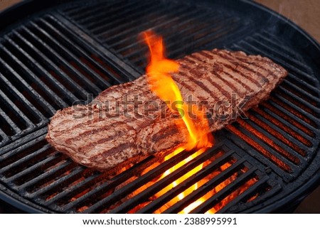 Traditional American barbecue bavette steak as close-up on a charcoal grill with fire Royalty-Free Stock Photo #2388995991
