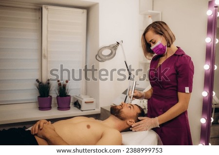  Man's head on electroporation facial therapy at beauty salon. . High quality photo