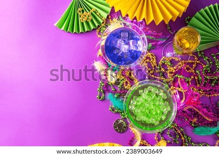 Mardi gras cocktails set. Colorful purple, yellow, green martini champagne wine cocktail glasses for Mardi gras party bar with carnival decor and orleans masquerade masks