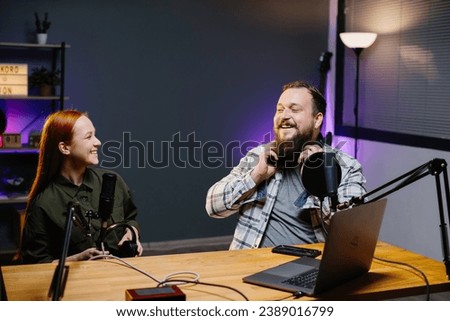 Online bloggers recording a new podcast episode in the studio. A guy and a girl in the studio during a stream in social networks, or a radio broadcast.