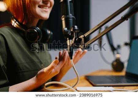 The girl radio presenter speaks into the microphone during the broadcast at the radio station. Online blogger during stream, close-up.