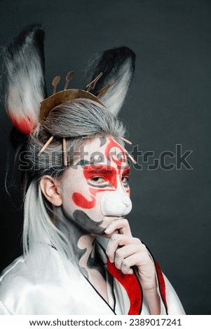Portrait of cute actress woman with stage makeup, rabbit mask and costume close up on black background. Halloween, Carnival, Performance and Theater concept