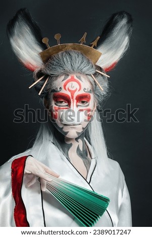 Attractive actress woman with stage makeup, rabbit mask and costume portrait on black background. Halloween, Carnival, Performance and Theater concept