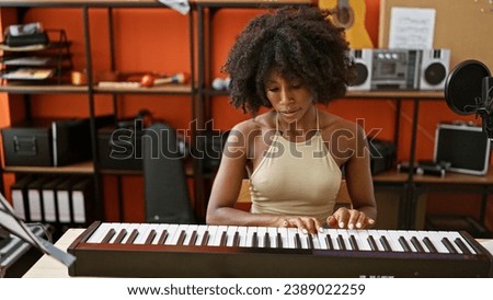 African american woman musician playing piano at music studio Royalty-Free Stock Photo #2389022259