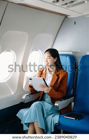 Attractive Asian female passenger of airplane sitting in comfortable seat while working laptop and tablet with mock up area using wireless connection. Travel in style, work with grace.
 Royalty-Free Stock Photo #2389040829