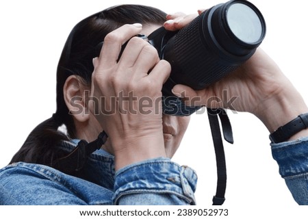 Portrait of a Caucasian woman covering her face with a camera, isolated on a white background. Professional photographer during shooting, the process of creating pictures.