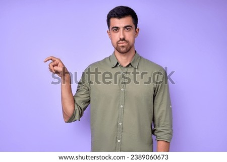 serious handsome man showing letter X x with fingers .the Alphabet in American Sign Language (ASL). isolated blue background closeup portrait