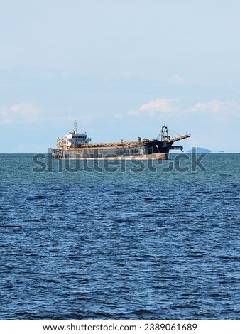 CARGO SHIP AT DOOR. The picture shows a cargo ship anchored in the waters near the port in the evening.