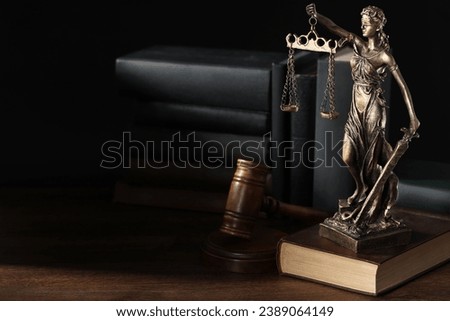 Symbol of fair treatment under law. Statue of Lady Justice near books and gavel on wooden table, space for text. Royalty-Free Stock Photo #2389064149