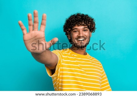 Photo portrait of handsome young guy stretch hand waving friendly dressed stylish striped yellow outfit isolated on cyan color background