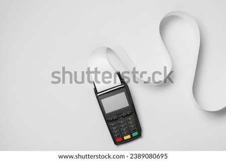 Payment terminal with thermal paper for receipt on light grey background, top view. Space for text