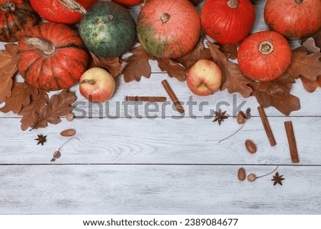 Orange pumpkinы, apples above copy space top view. Dry yellow oak leaves, acorns, spices on white wooden Thanksgiving table background. Autumn, fall menu, holiday, harvest season