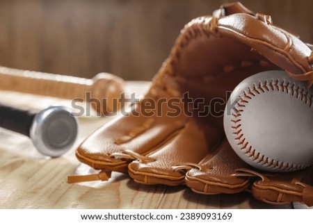 Baseball glove and ball on wooden table, closeup