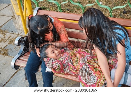 three cheerful latin girls sitting in a park in latin america bolivia