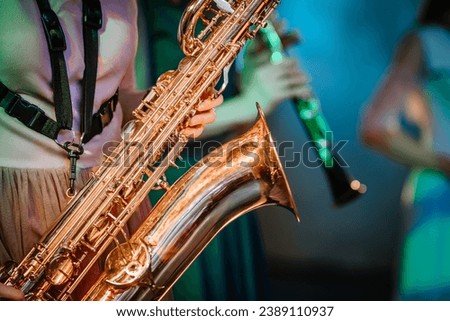 Musician playing saxophone on blurred background, melody music sound.
 Royalty-Free Stock Photo #2389110937