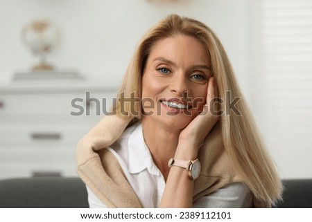 Portrait of smiling middle aged woman with blonde hair indoors