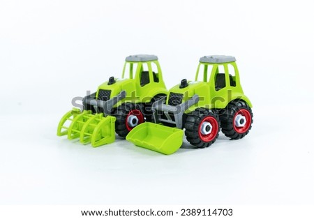 Group of cars ,Children's toy green tractor on a white isolated background.Plastic child toy on white backdrop. Construction vehicle. Children's toy. Tractor Toy.