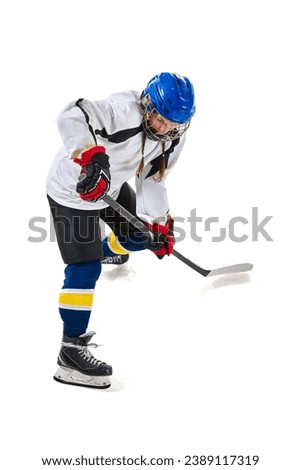 Young girl, hockey playing in helmet, uniform, with stick training, playing isolated over white background. Concept of professional sport, competition, game, action, hobby, achievements