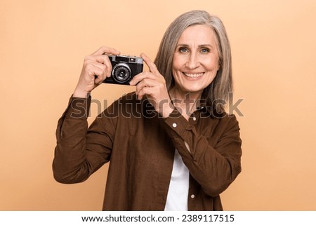Photo of nice satisfied aged person toothy smile hands hold retro photo camera isolated on beige color background