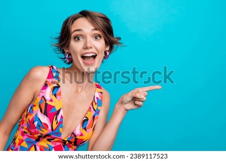 Photo of impressed funky girl dressed print outfit pointing finger empty space isolated blue color background