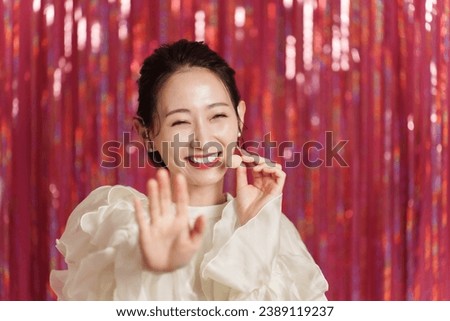attractive asian idol singing on stage with headset  Royalty-Free Stock Photo #2389119237