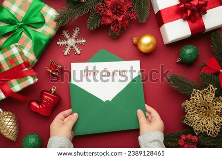 Christmas letter from a child to Santa Claus with the words: Dear Santa. Christmas composition with yellow and green toys. Top view