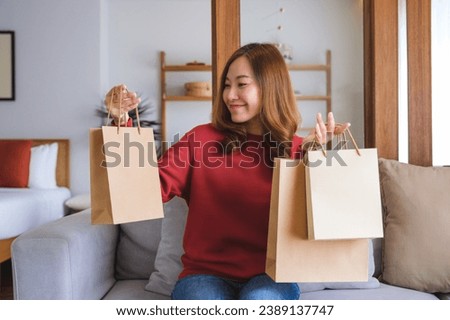 Portrait image of a young woman holding shopping bags at home