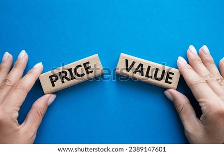 Price and Value symbol. Concept word Price and Value on wooden blocks. Businessman hand. Beautiful blue background. Business and Price and Value concept. Copy space