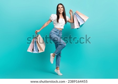 Full length photo of sweet excited girl dressed white top rising shoppers isolated teal color background