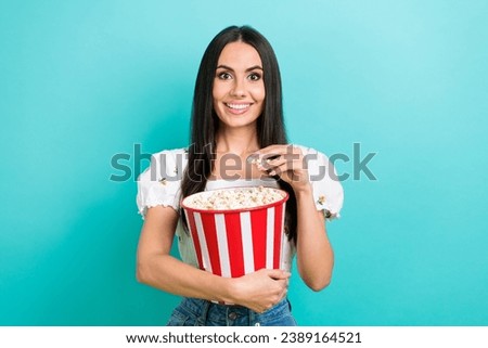 Photo of cute excited lady wear white blouse watching film eating pop corn isolated turquoise color background
