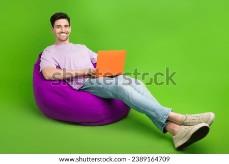 Full length photo of cheerful man dressed stylish clothes relax rest soft chair empty space isolated on green color background