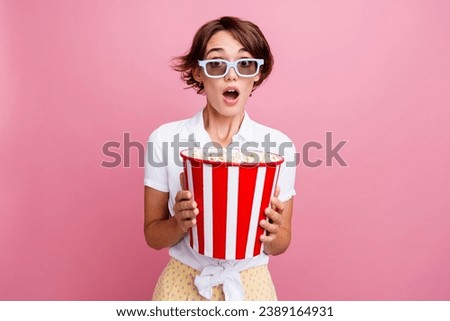 Photo of astonished girl dressed white shirt in 3d glasses eat popcorn staring at interesting movie isolated on pink color background