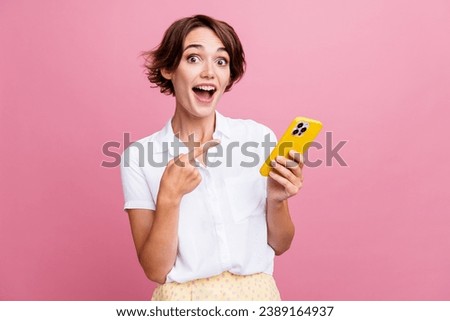 Photo of ecstatic impressed girl with bob hairdo dressed white shirt directing at smartphone staring isolated on pink color background Royalty-Free Stock Photo #2389164937
