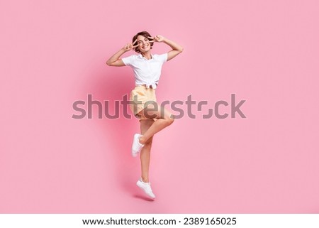 Full length photo of jumping trampoline funky active lady wearing spring season apparel cover eyes v sign isolated on pink color background