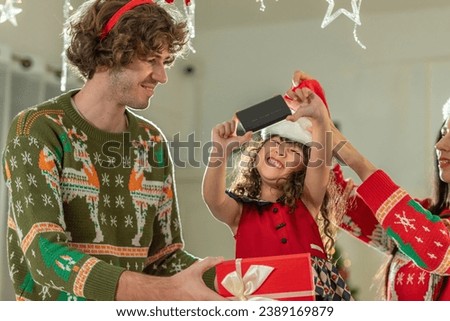 Baby enjoy Christmas decorate Gift box present on colorful pine tree with laugh smile happy parent family celebrate party in Christmas day at home. Kid daughter girl enjoy Christmas party dance