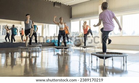 Group of people exercising on mini trampolines in a bright fitness studio Royalty-Free Stock Photo #2389170219