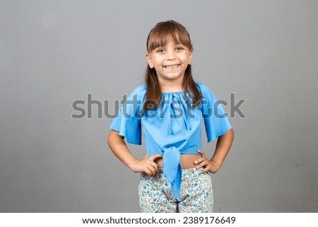 Adorable little caucasian girl with hands on waist smiling looking at camera with free space for text