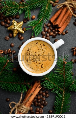 A cup of coffee on a table with New Year and Christmas decorations. Top view, on a black background, free copy space. Holiday.