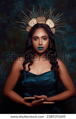 creative portrait shoot of a female model wearing a crown ad a green dress 